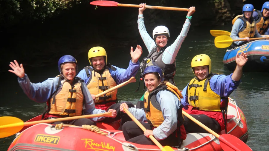 Happy rafting group posing with paddles after white water adventure on the Rangitikei River