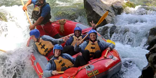 Excited rafting group dropping into a rapid on the Rangitikei River in New Zealand