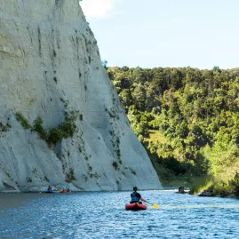 Inflatable kayaks paddling below the steep papa bluffs on the Rangitikei River