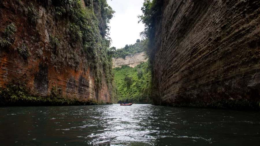 Raft floating through a deep vertical canyon on the Rangitikei River