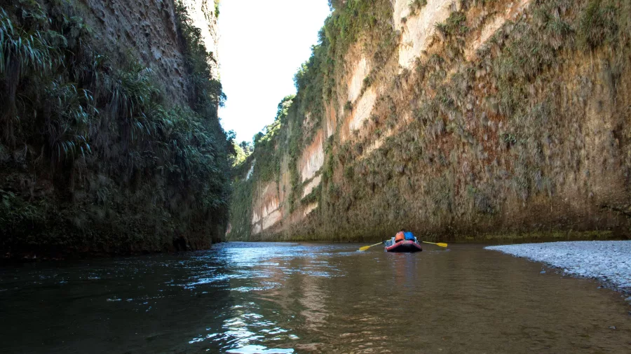 Raft entering Mokai Canyon on the Rangitikei River with sheer vertical cliffs