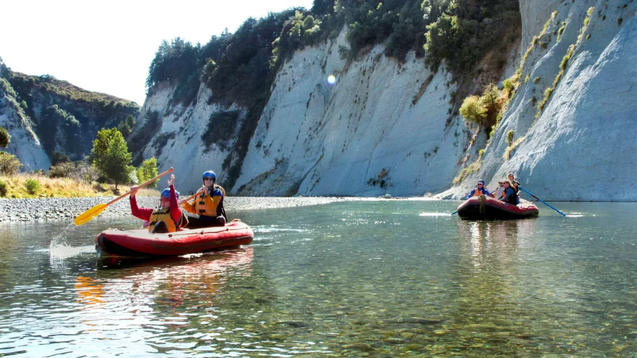 Rafts passing dramatic white cliffs on a calm stretch of the Rangitikei River