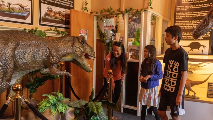 Family looking at a large dinosaur model at Dinosaur House in Raetihi