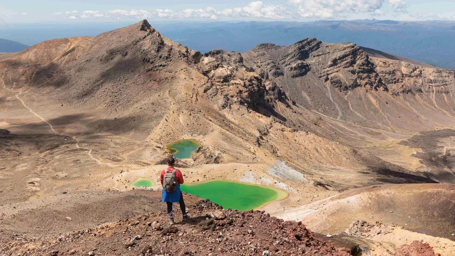 Hiker overlooking the Emerald Lakes on Tongariro Alpine Crossing