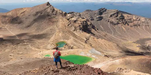 Hiker overlooking the Emerald Lakes on Tongariro Alpine Crossing