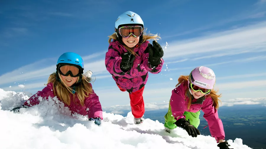 Three children playing in snow at Tūroa Ski Field, Mt Ruapehu