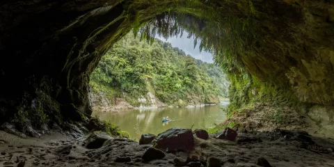 Canoe on the Whanganui River seen from inside Tematea’s Cave