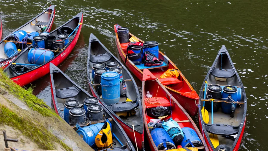Canoes packed with barrels and supplies along the Whanganui River
