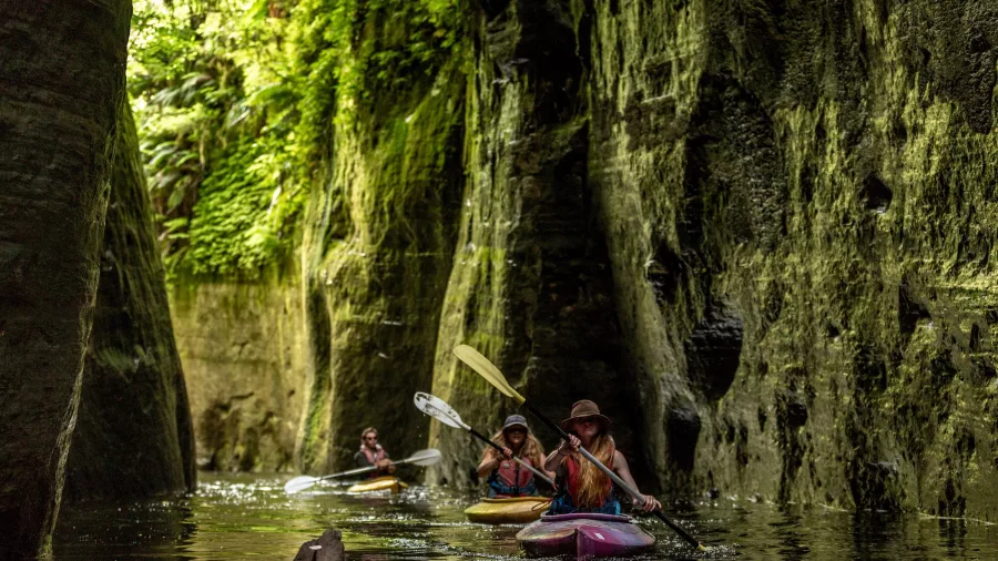 Kayakers paddling through a narrow gorge at Blue Duck Station on the Whanganui River