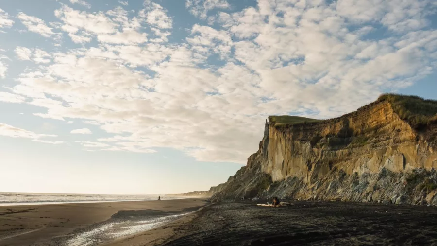 Golden cliffs and black sand at Kai Iwi Beach near Whanganui at sunset