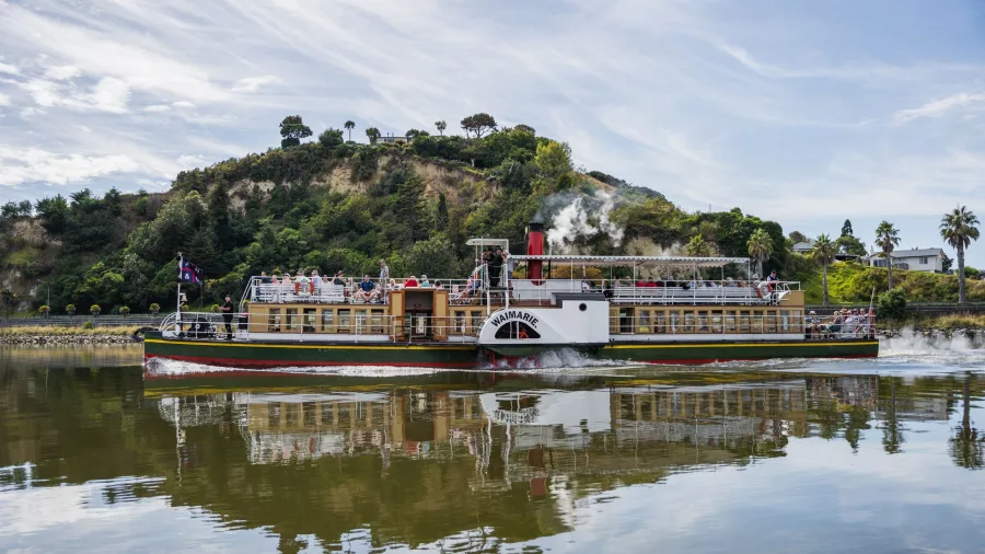 Paddle steamer Waimarie cruising along the Whanganui River with hills in the background