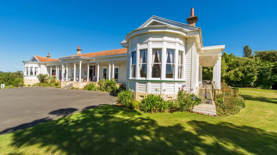 Historic Bushy Park Homestead in Whanganui surrounded by lush gardens and lawn