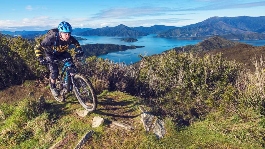Mountain biker riding along a ridge with views of the Marlborough Sounds