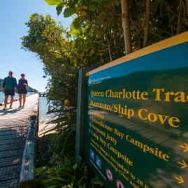 Signpost at Ship Cove marking Queen Charlotte Track distances in the Marlborough Sounds