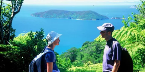 Couple enjoying views from Ship Cove Lookout along the Queen Charlotte Track, Marlborough Sounds