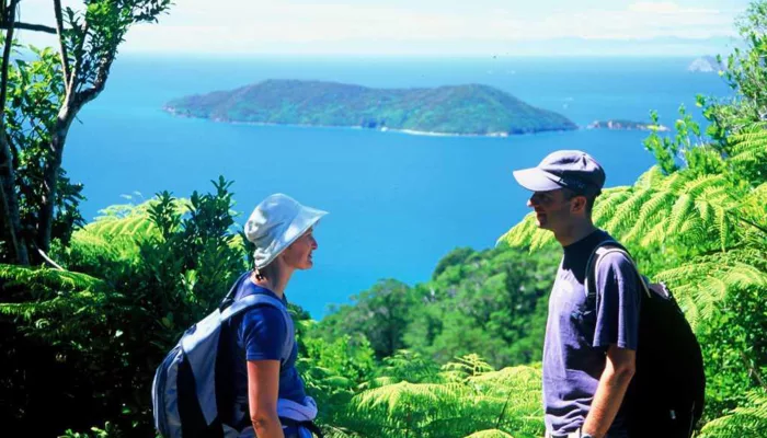 Couple enjoying views from Ship Cove Lookout along the Queen Charlotte Track, Marlborough Sounds