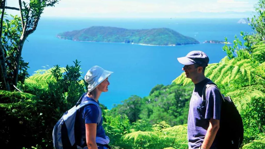 Couple enjoying views from Ship Cove Lookout along the Queen Charlotte Track, Marlborough Sounds