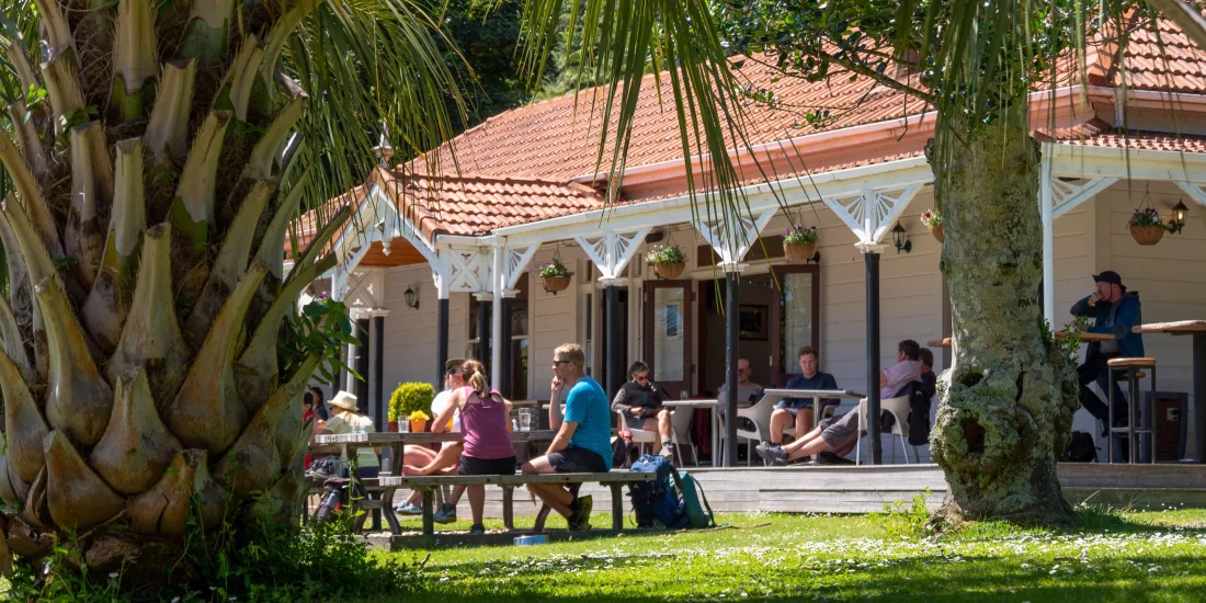 Guests enjoying outdoor dining in the garden at Furneaux Lodge on the Queen Charlotte Track