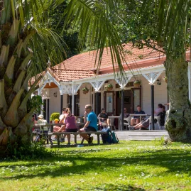 Guests enjoying outdoor dining in the garden at Furneaux Lodge on the Queen Charlotte Track