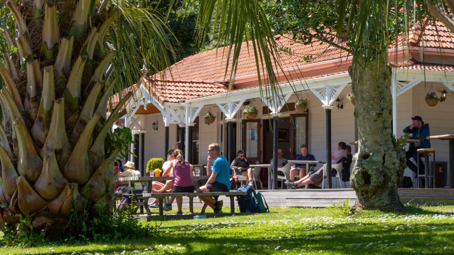 Guests enjoying outdoor dining in the garden at Furneaux Lodge on the Queen Charlotte Track