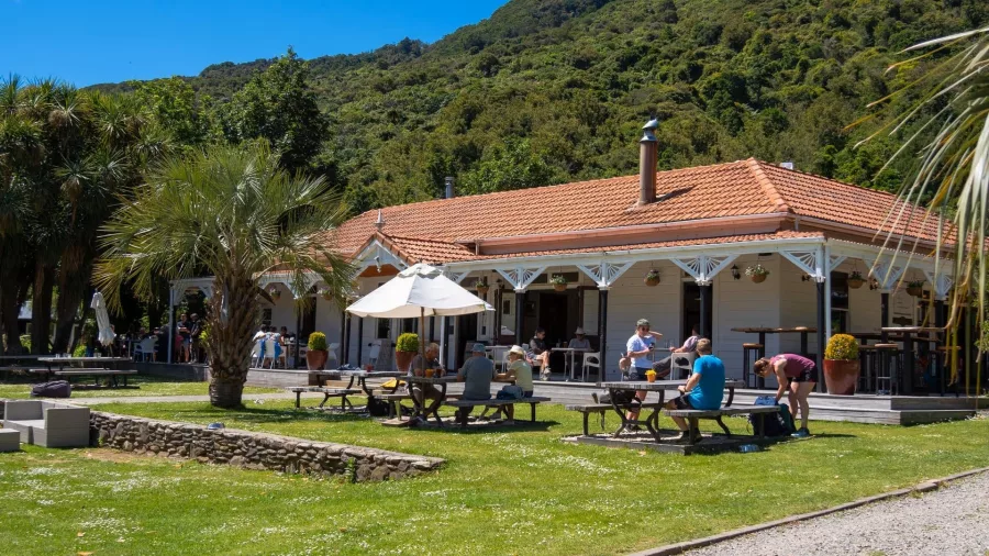 Guests relaxing in the garden at Furneaux Lodge on the Queen Charlotte Track, Marlborough Sounds.