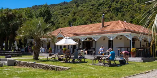 Guests relaxing in the garden at Furneaux Lodge on the Queen Charlotte Track, Marlborough Sounds.