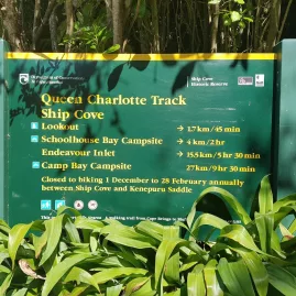 Department of Conservation trail sign with directions and distances from Ship Cove on the Queen Charlotte Track.