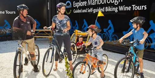 Family preparing for a biking wine tour in Marlborough with kids and cycle trailer