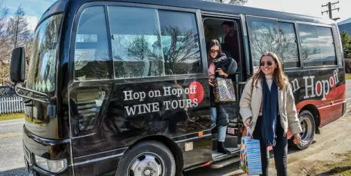 Guests stepping off the Hop On Hop Off Wine Tour bus in Bannockburn, Central Otago