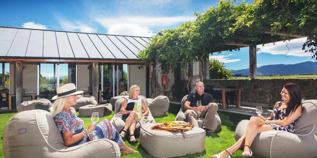 Guests enjoying wine and a shared food platter on bean bags at Wither Hills Winery in Marlborough
