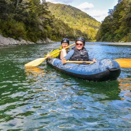 Smiling couple kayaking on the clear waters of the Pelorus River on a guided Hobbit tour