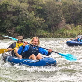 Excited kayakers paddling through gentle rapids on the Pelorus River at Havelock