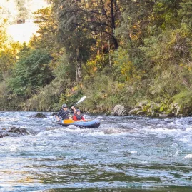 Two people paddling through small rapids on the Pelorus River during a Hobbit-themed kayak tour