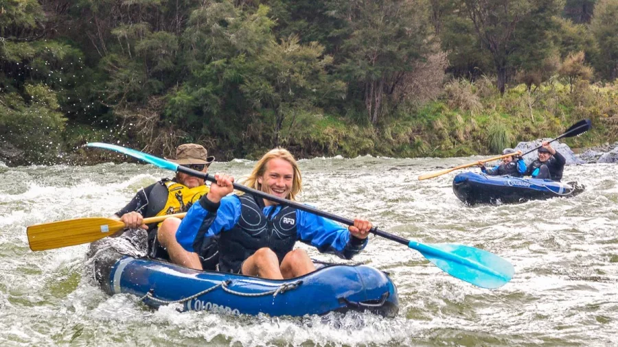 Excited kayakers paddling through gentle rapids on the Pelorus River at Havelock