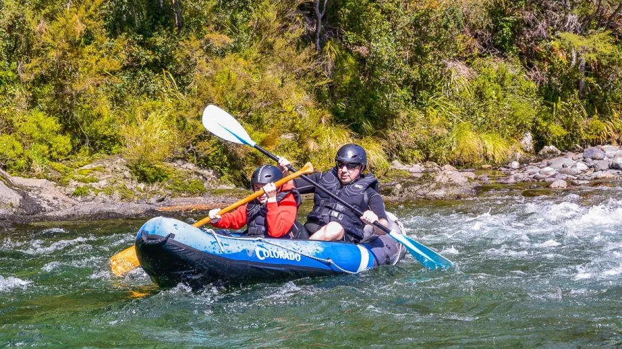 Father and son kayaking through a bend on the Pelorus River during a Hobbit-themed tour