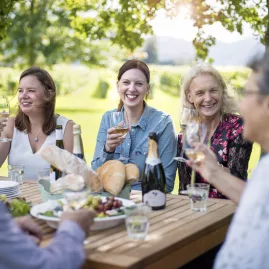 Group enjoying lunch and wine under a tree in Marlborough vineyard