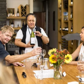 Group enjoying a hosted wine tasting around a table at a Marlborough winery
