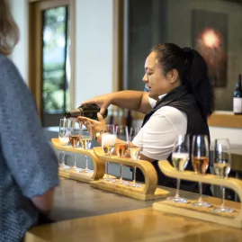 Cellar door staff pouring a wine flight tasting in Marlborough winery