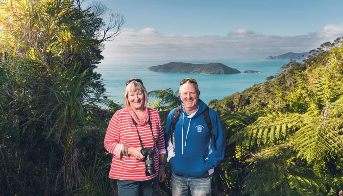 Smiling couple enjoying views of the Marlborough Sounds from Queen Charlotte Track