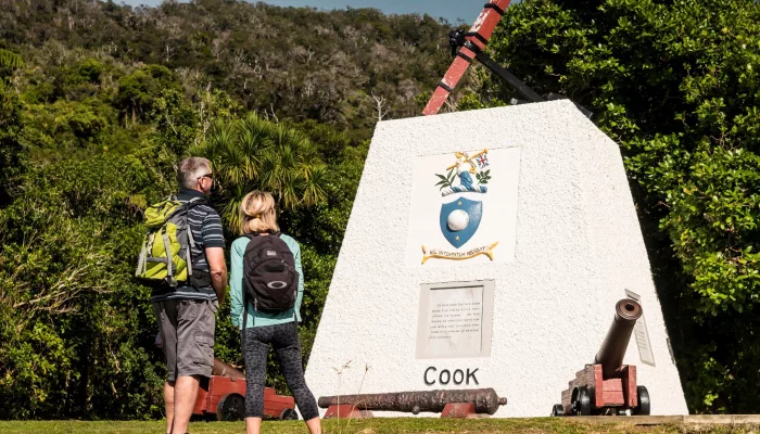 Couple looking at the Captain Cook monument at Ship Cove, Marlborough Sounds