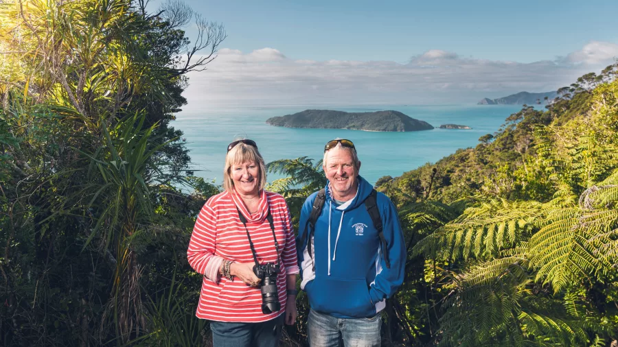 Smiling couple enjoying views of the Marlborough Sounds from Queen Charlotte Track