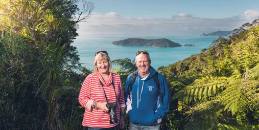 Smiling couple enjoying views of the Marlborough Sounds from Queen Charlotte Track