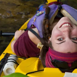 Young woman smiling and relaxing in her kayak on Queen Charlotte Sound