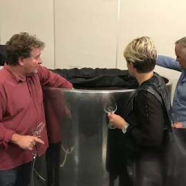 Wine tasting guests exploring a Pinot Noir fermentation tank at Mahi Wines in Marlborough.