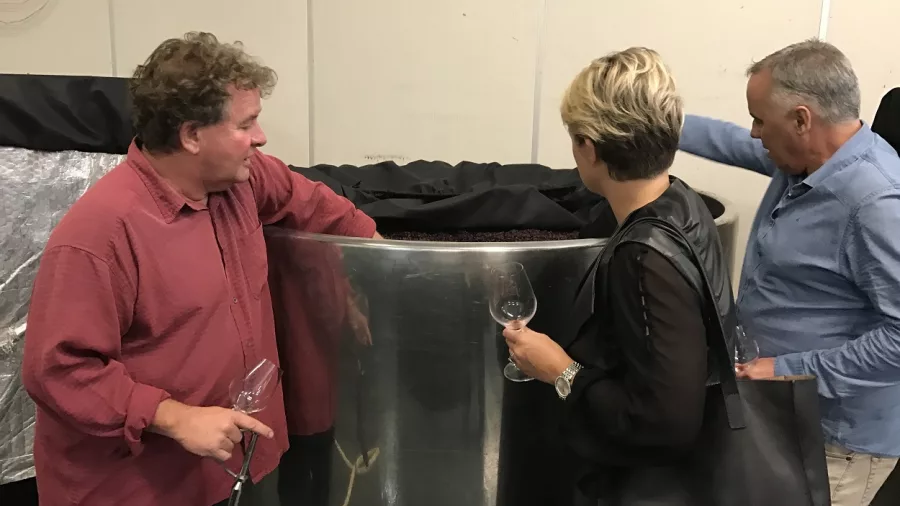 Wine tasting guests exploring a Pinot Noir fermentation tank at Mahi Wines in Marlborough.