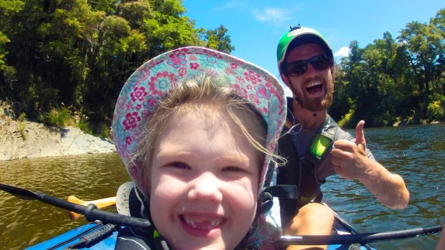 Smiling child and guide enjoying a kayak on the clear waters of Pelorus River in Marlborough.