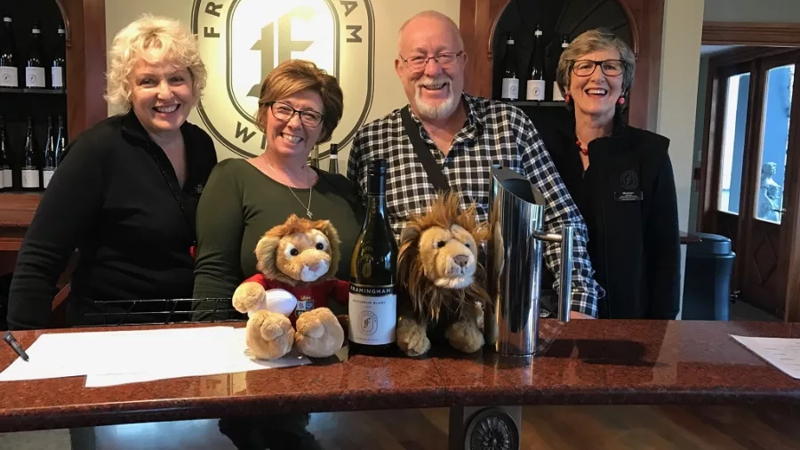 Wine lovers smiling at the tasting counter inside Framingham Wines in Marlborough, New Zealand.