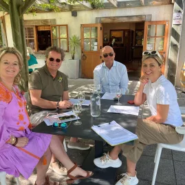 Group of wine tourists seated outdoors enjoying a Marlborough tasting experience.