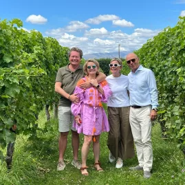 Four friends posing in a lush green vineyard in Marlborough.