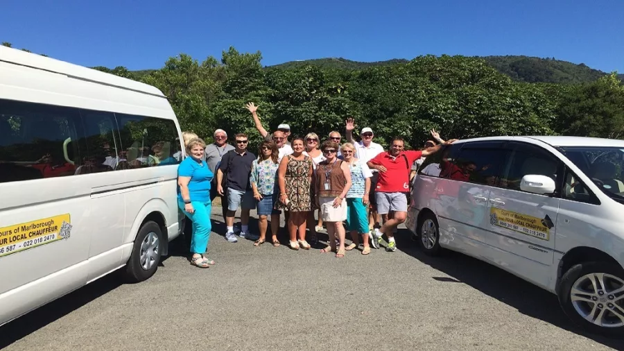 Tour group standing beside Your Local Chauffeur vans in Marlborough.